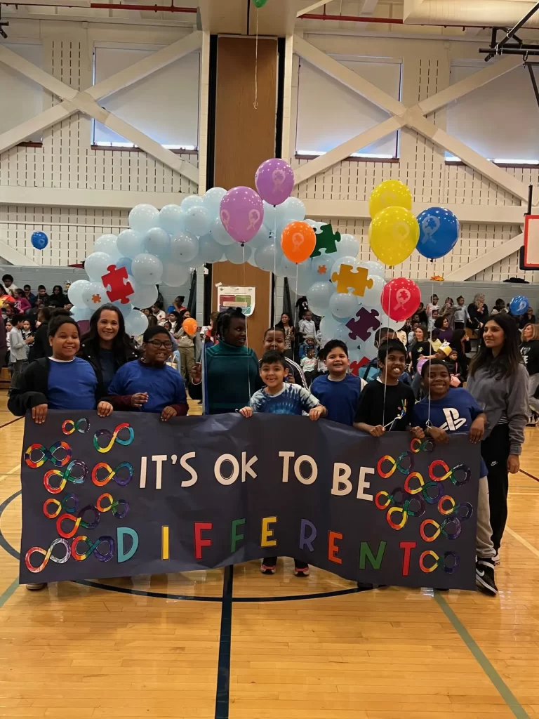 students holding a banner with the words it is ok to be different