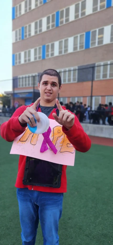 student wearing pink holding a breast cancer fundraiser banner