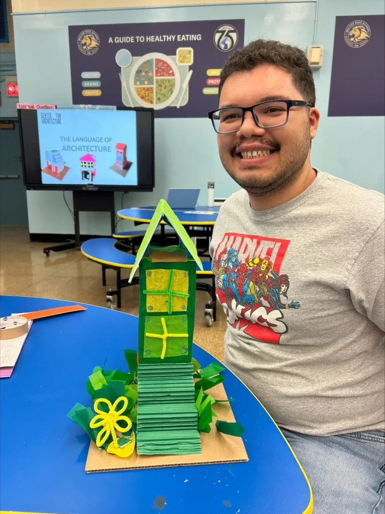 Student with his house art project