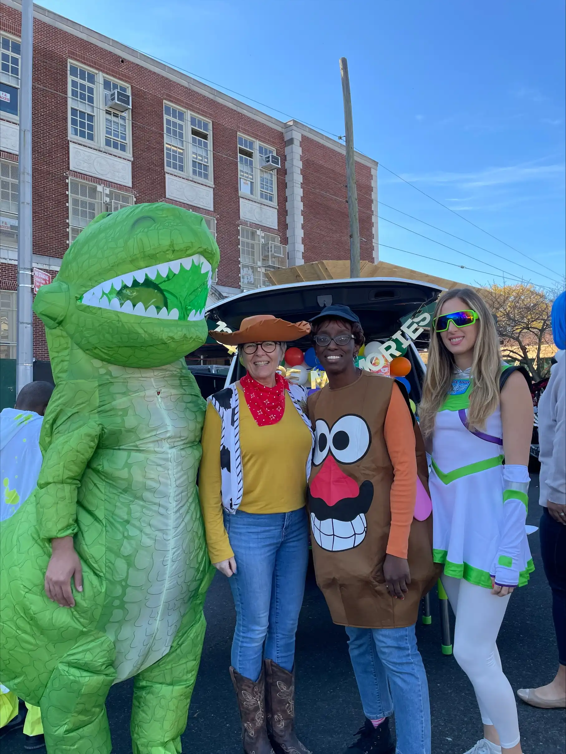 four teachers in Halloween costumes in the school yard.