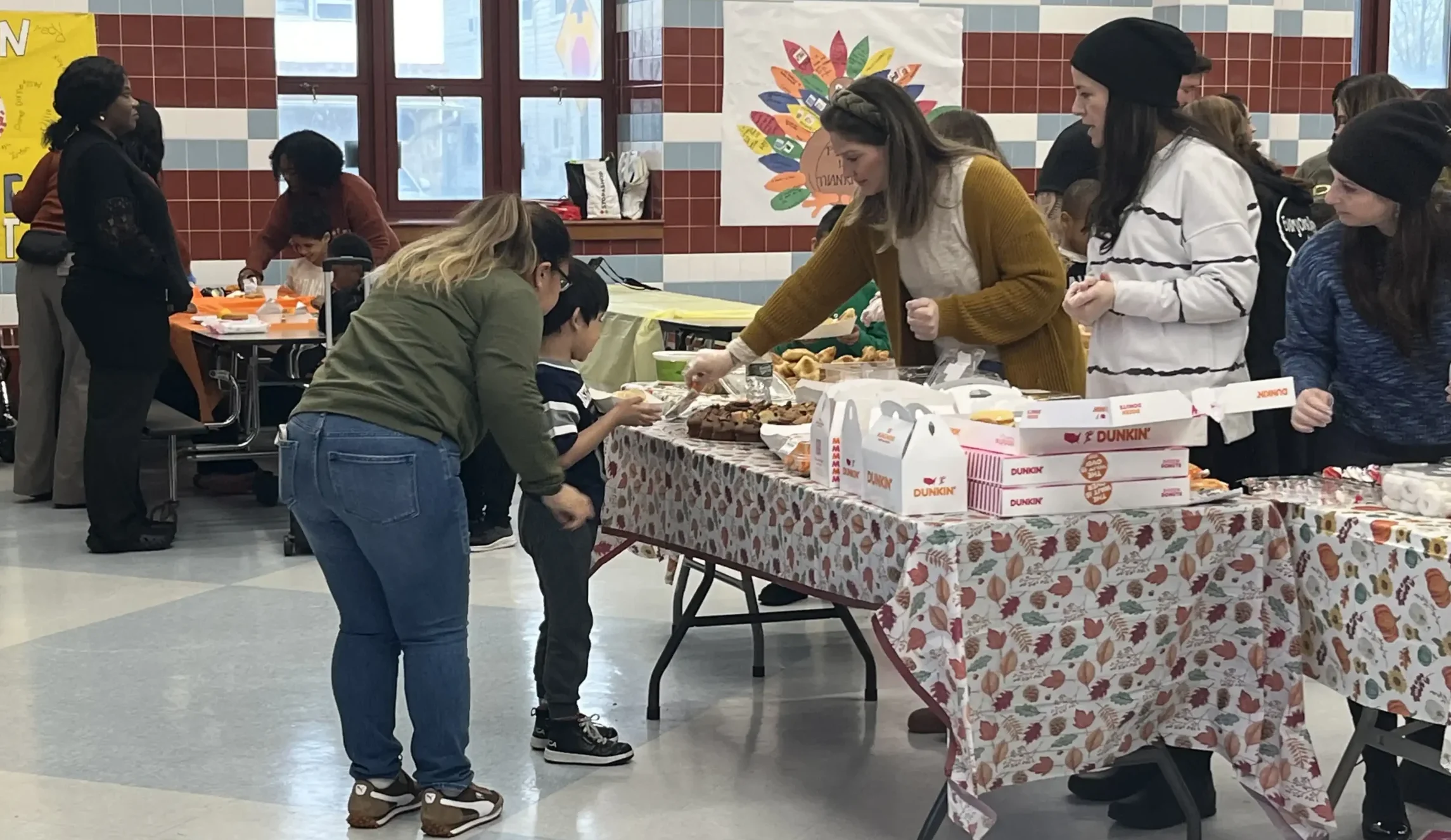 Teachers serving baked goods in the cafeteria