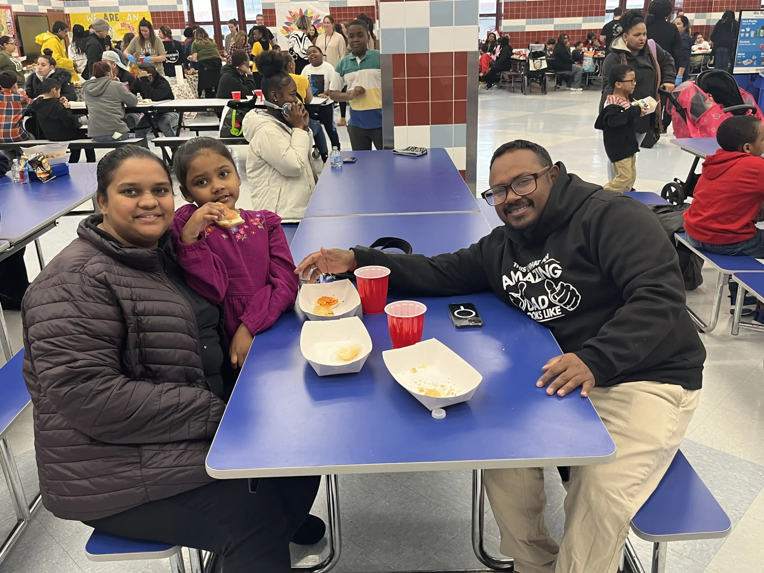 a family of 3 eating together in the cafeteria