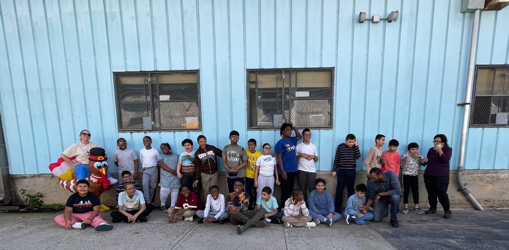 Group shot of students in front of a blue wall